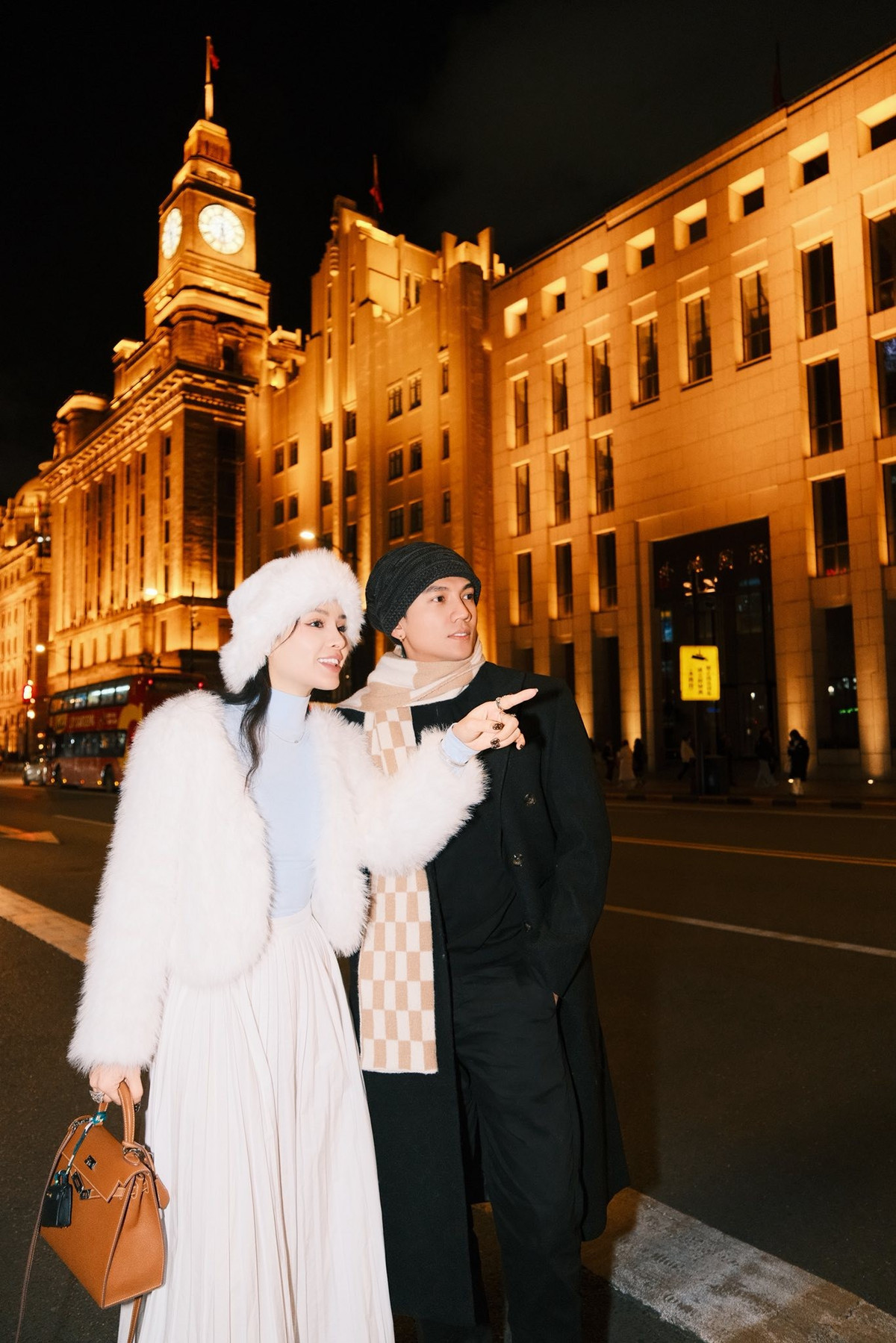 Trong bộ ảnh, Phương Trinh Jolie nổi bật với trang phục tone trắng thanh lịch. Cô diện áo khoác lông trắng phối cùng mũ lông trắng và chân váy đồng màu, mang đến vẻ ngoài vừa sang trọng vừa ấm áp. Trong khi đó, Lý Bình chọn “cây đen” nam tính, tối giản nhưng vẫn toát lên phong thái lịch lãm, tạo sự tương phản ấn tượng khi đứng cạnh bà xã.