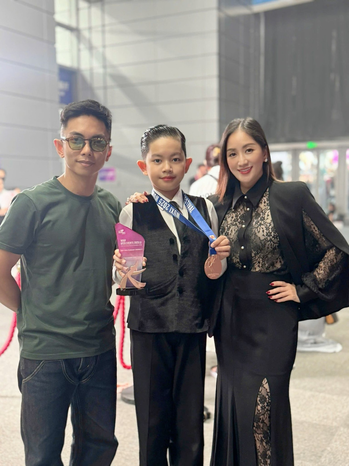 Kubi khoe huy chương đồng tại Asian DanceSport Festival 2025 với bố mẹ. Ảnh: FB Nguyen Khanh Thi