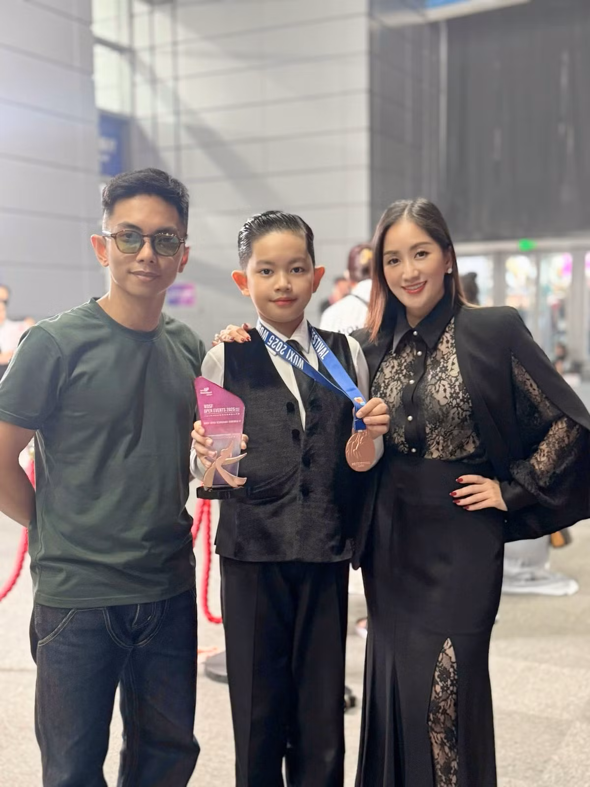 Kubi khoe huy chương đồng tại Asian DanceSport Festival 2025 với bố mẹ. Ảnh: FB Nguyen Khanh Thi