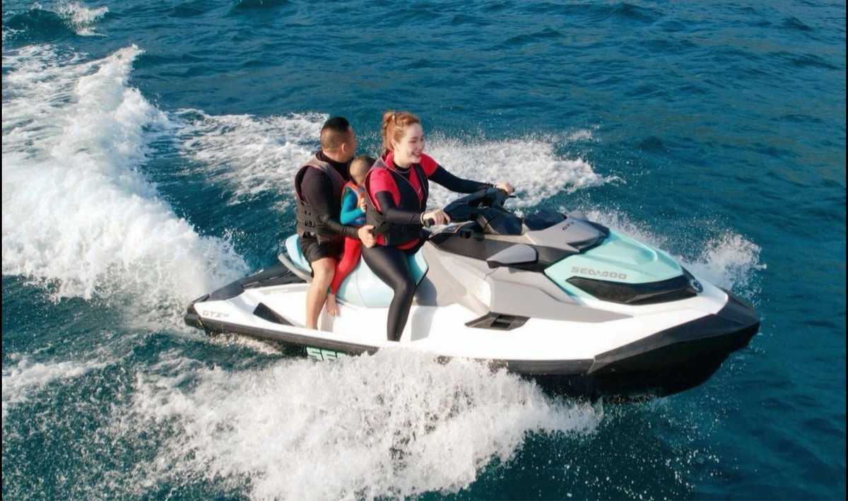 Bảo Thy lái cano chở ông xã và con trai lướt sóng biển. Ảnh: FB Bảo Thy