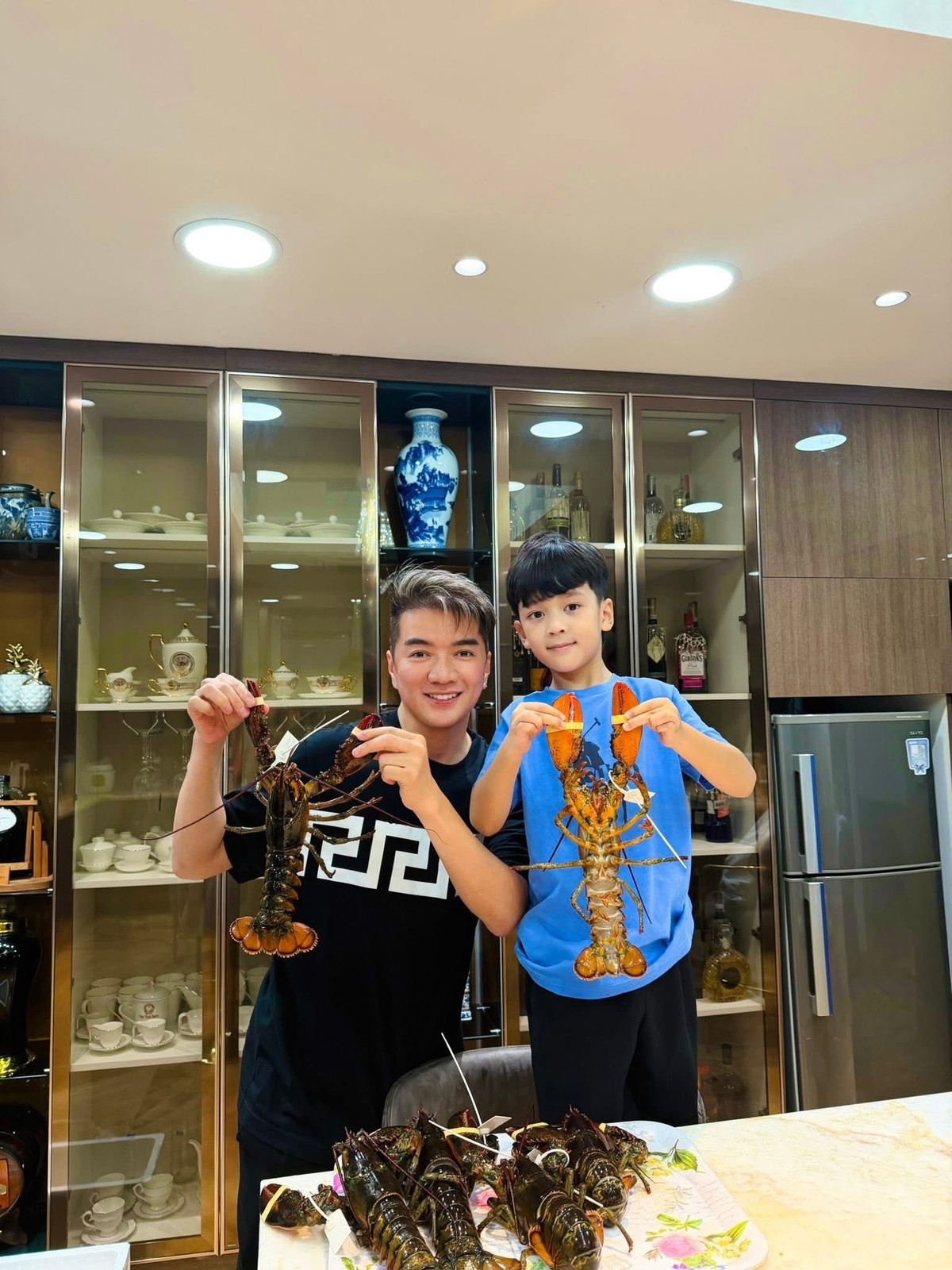 Đàm Vĩnh Hưng và con trai Polo hào hứng khi được một người bạn gửi tặng rất nhiều tôm hùm tươi sống. Ảnh: FB Đàm Vĩnh Hưng