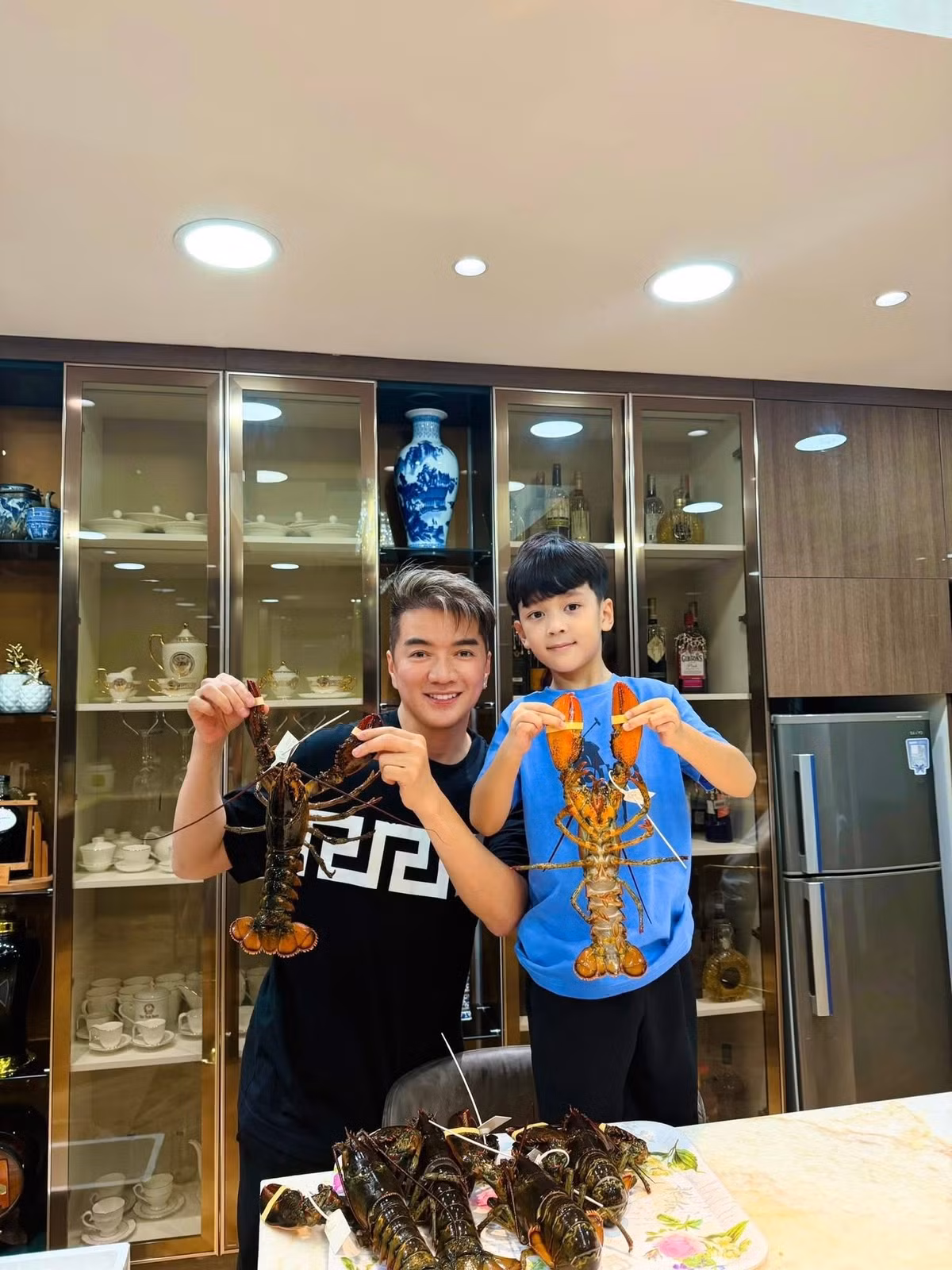 Đàm Vĩnh Hưng và con trai Polo hào hứng khi được một người bạn gửi tặng rất nhiều tôm hùm tươi sống. Ảnh: FB Đàm Vĩnh Hưng