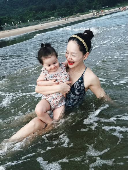Diễn viên Lan Phương bế con gái nhỏ chơi đùa trên biển. Ảnh: FB Lan Phuong Nguyen