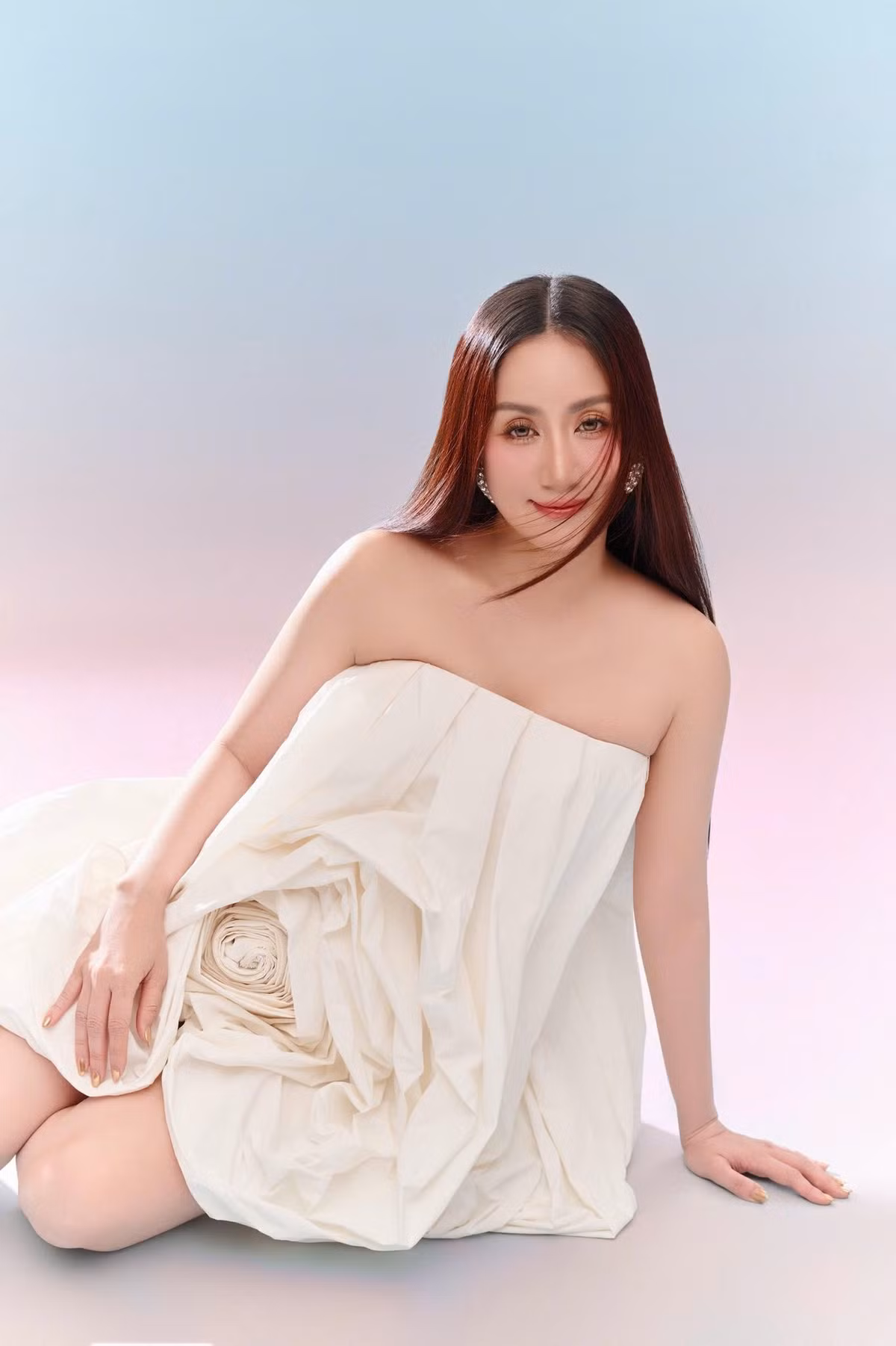 Trong bộ ảnh, Khánh Thi diện chiếc váy trắng bất đối xứng, được tạo hình như một đóa hoa đang nở. Chất liệu nhẹ cùng phom váy suông bay bổng, phần thân xếp nếp thành cánh hoa lớn tạo nên tổng thể vừa nghệ thuật vừa hiện đại.