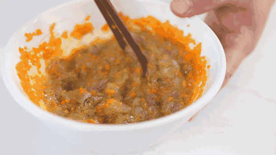 Bước 3: Bạn đập 1 quả trứng vào một âu bát lớn, trong đó chứa cà rốt và tôm băm nhỏ rồi nêm chút muối, rượu nấu ăn vào bát. Lấy đũa đánh đều hỗn hợp này.