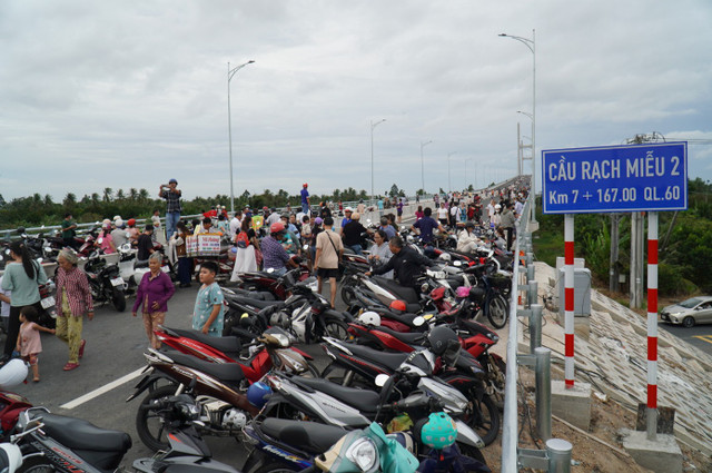Nhiều người bán hàng rong tụ tập mua bán trên cầu Rạch Miễu 2. Nhiều người bán hàng rong tụ tập mua bán trên cầu Rạch Miễu 2.