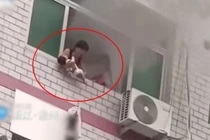 Bà mẹ bất lực ném con khỏi cửa sổ toà nhà đang cháy