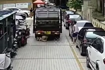 Mải xem điện thoại, người phụ nữ bị xe chở rác cuốn vào gầm