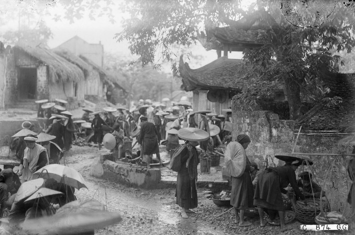 Chợ làng Bưởi ở huyện Hoàn Long (gồm hai huyện Thọ Xương và Vĩnh Thuận cũ), tỉnh Hà Đông năm 1926, nay thuộc phường Bưởi, quận Tây Hồ, Hà Nội.