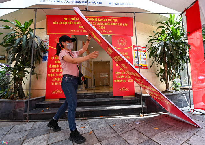 Cán bộ phường Hàng Mã đang tất bật trang trí băng rôn, biểu ngữ tại điểm bỏ phiếu số 2 của phường Hàng Mã (quận Hoàn Kiếm, Hà Nội). Địa bàn phường này có 8 điểm bỏ phiếu, trong đó có tới 5 điểm phải lắp đặt bằng nhà bạt ngoài trời nên mất khá nhiều thời gian.