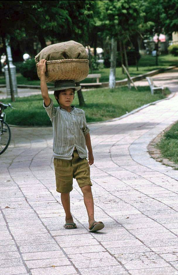 Một em bé bán hàng rong đi trên vỉa hè hồ Hoàn Kiếm, 1992.