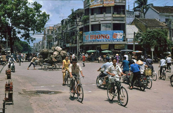 Trên đường Hùng Vương ở Đà Nẵng năm 1991. Các trạm xăng công cộng còn rất hiếm nên các quầy xăng lẻ xuất hiện phổ biến bên vỉa hè (phía trái). Trên đường phố, xe đạp nhiều hơn xe máy. Xe chở hàng siêu cồng kềnh ung dung đi qua ngữ tư.