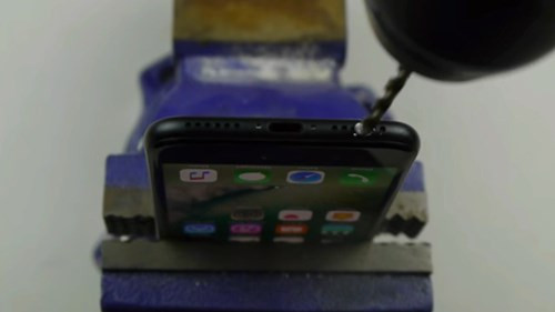 Theo đoạn video này, để tạo lỗ cắm tai nghe trên thân iPhone 7/7 Plus, người dùng cần sử dụng một chiếc khoan với mũi khoan 3,5mm. Sau đó, kẹp cố định chiếc điện thoại theo chiều thẳng đứng, xác định vị trí lỗ khoan rồi bấm máy.