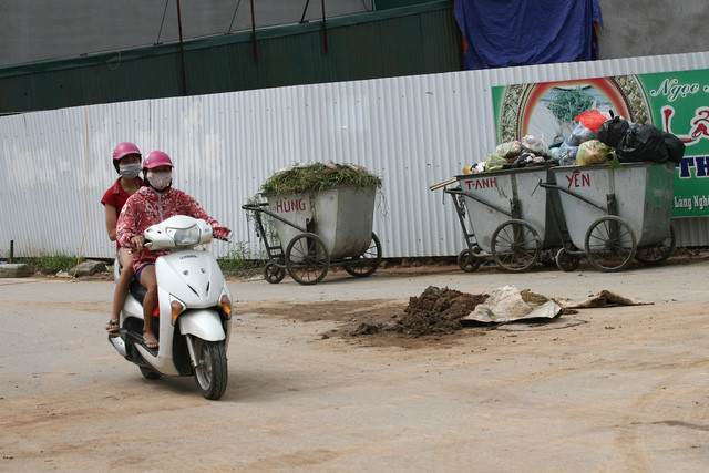 Rất nhiều điểm tập kết rác không phủ bạt, che chắn các xe thu gom.