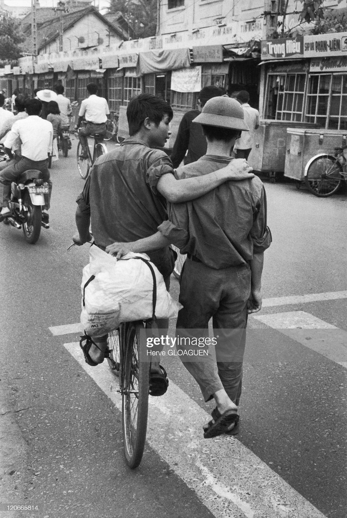 Hai người lính trẻ trò chuyện với nhau trên đường phố.