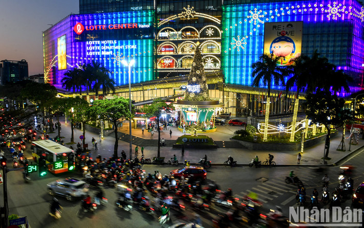 Khu vực sảnh lớn trước cửa trung tâm thương mại Lotte nằm trên phố Đào Tấn (quận Ba Đình), cây thông lớn cao hơn 20m đã được dựng lên, trang hoàng lộng lẫy làm nổi bật một góc phố.