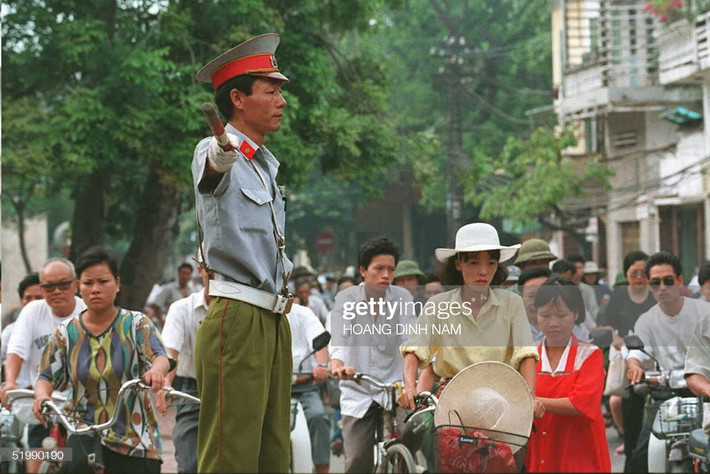 Một cảnh sát giao thông điều khiển phương tiện giao thông trong giờ cao điểm tại góc phố Hàng Gai - Hàng Đào, phố cổ Hà Nội. Ảnh chụp ngày 1/8/1995, ngày mà những mức phạt mới, từ 200.000 đến 50 triệu đồng, được áp dụng cho các hành vi vi phạm luật giao thông.