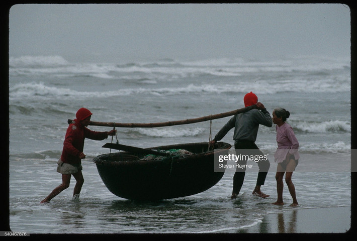 Ngư dân khiêng thuyền thúng trên bãi biển Mỹ Khê, Đà Nẵng năm 1994.