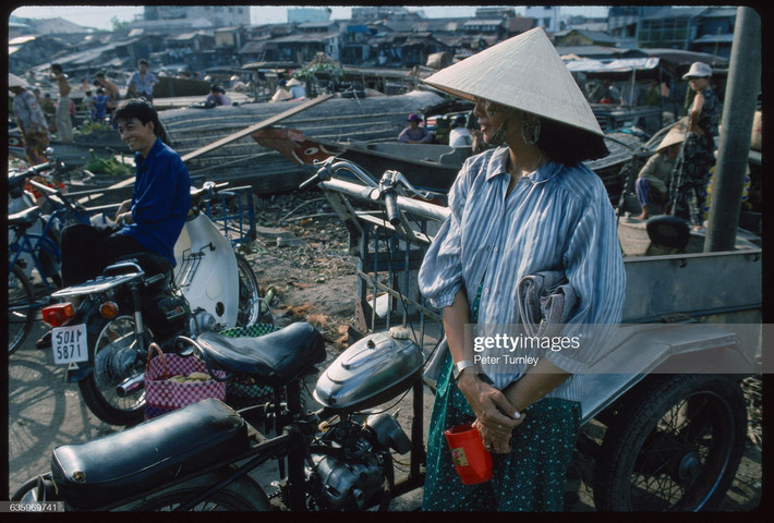 Xe thồ, xe đạp, xe máy, ghe thuyền... tại khu chợ họp bên bờ kênh.