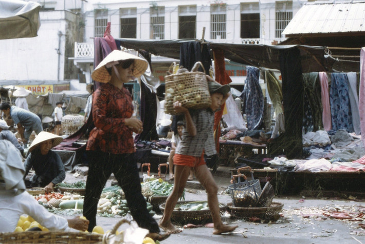 Chú bé vác giỏ hoa quả ở khu chợ dọc bến Ninh Kiều.