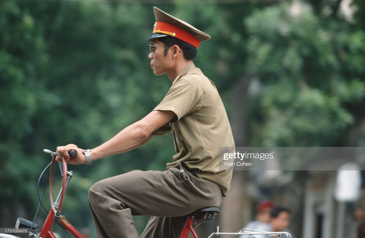 Chiến sĩ trẻ đạp xe trên đường.