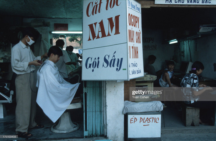 Hiệu cắt tóc cạnh cửa hàng photocopy trên phố Quang Trung, Hà Nội năm 1996. Ảnh: Yvan Cohen/LightRocket via Getty Images.