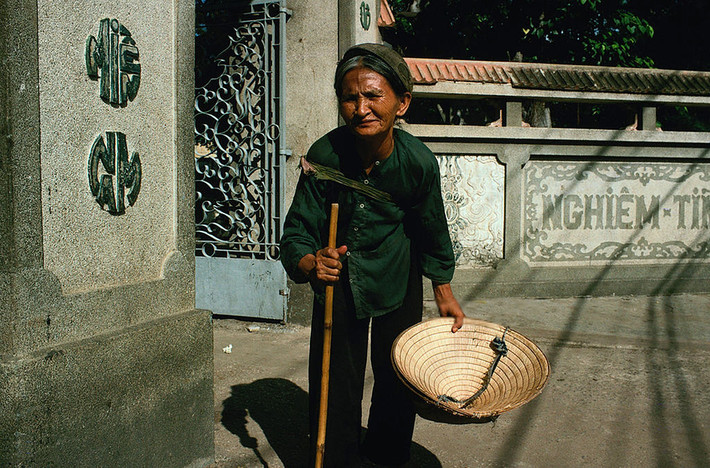 Cụ bà hành khất hành nghề trước cổng chùa Vĩnh Nghiêm năm 1971, năm chùa khánh thành. Ảnh: Richard I'Anson.
