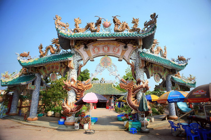 Cổng miếu bề thế với hình rồng đắp nổi trên cột và các mái.
