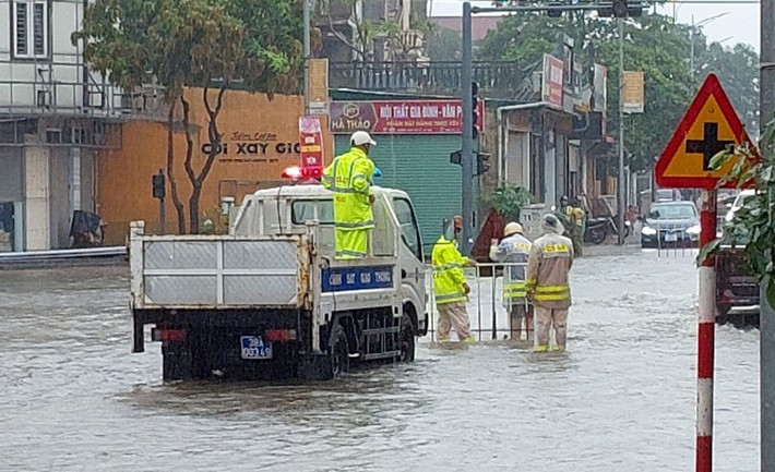 Mưa lớn cũng khiến nhiều tuyến đường ở TP Hà Tĩnh, thị xã Kỳ Anh ngập sâu. Lực lượng CSGT phải túc trực, cắm biển cảnh báo đường ngập và hỗ trợ người đi đường.