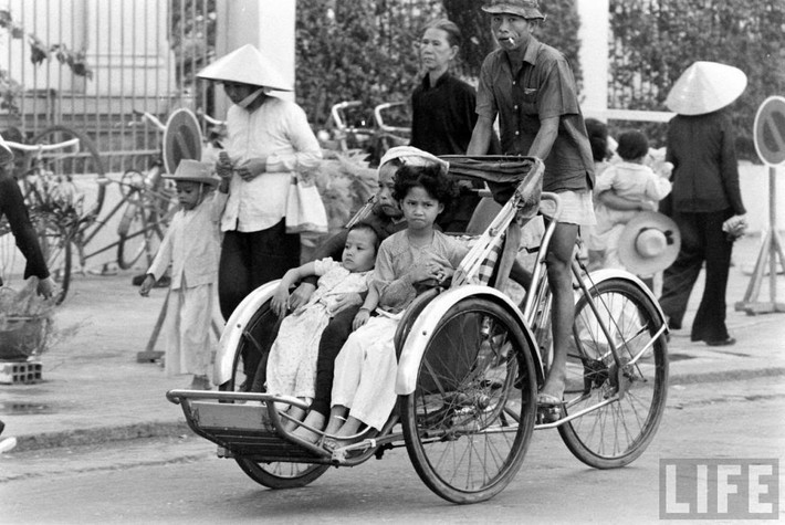 Người lái xích lô chở ba mẹ con.