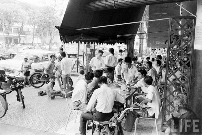 Trẻ em đánh giày chờ khách tại một quán cà phê vỉa hè.