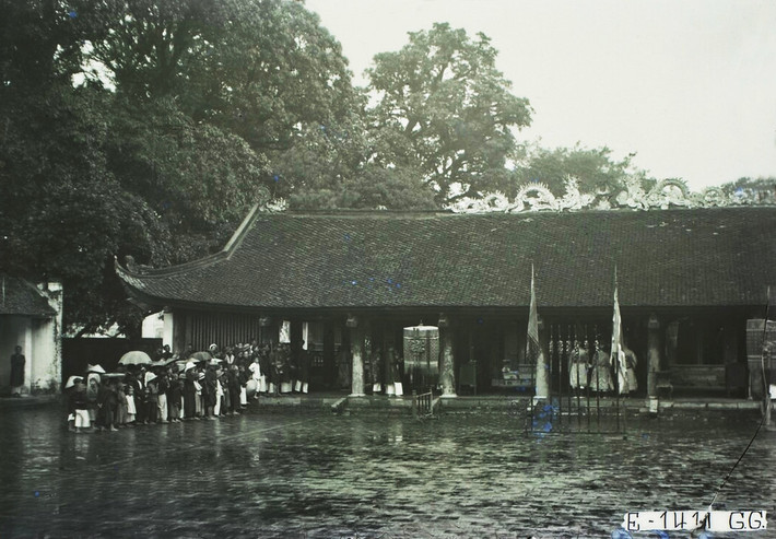 Người dân đội mưa, xếp hàng chờ vào hành lễ ở nhà Đại Bái Đường, Văn Miếu - Quốc Tử Giám, Hà Nội thập niên 1920.