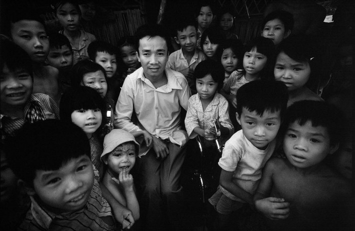 Trẻ em tập trung quanh một thương binh để nghe kể chuyện.
