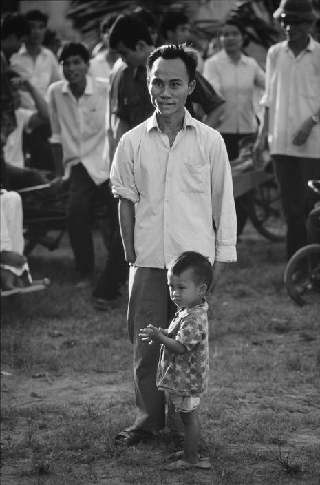 Người thương binh Việt Nam và đứa con xem đá bóng, 5 năm sau khi cuộc kháng chiến chống đế quốc Mỹ kết thúc.
