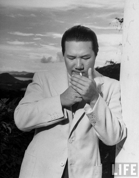 Bảo Đại ăn vận chải chuốt, tay châm thuốc lá ở Hồng Kông, tháng 6/1948. Vị vua cuối cùng của Việt Nam có dáng vóc cao lớn, điển trai, luôn tràn đầy phong độ. Ông được cho là cưỡi ngựa điêu luyện như một kỵ sĩ trung cổ, chơi golf, tennis giỏi như một quán quân hàng tỉnh, bơi thuyền các loại như một vận động viên Olympic... Hình ảnh do tạp chí Life thực hiện.