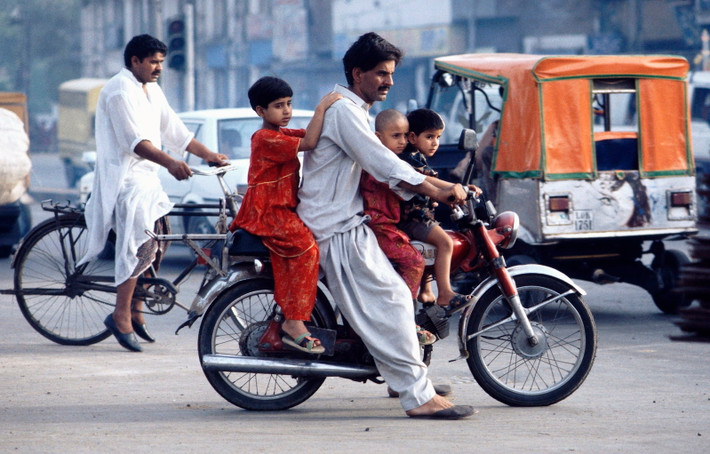 Người đàn ông chở ba đứa trẻ trên xe máy ở Lahore, thủ phủ tỉnh Punjab, thành phố lớn thứ hai Pakistan, năm 1995.