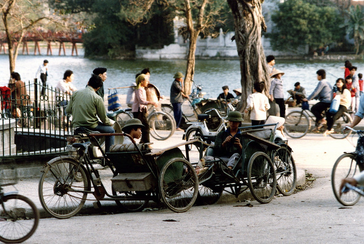 Khu vực đài phun nước Long Vân bên bờ hồ Hoàn Kiếm, phía xa là cầu Thê Húc và đền Ngọc Sơn, Hà Nội năm 1990. Ảnh: Diligam_te Flickr.