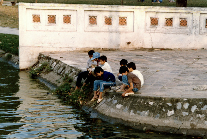 Những đứa trẻ câu cá bên lối vào đền Ngọc Sơn.