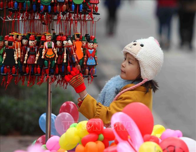 Một em nhỏ lựa chọn mua một món quà trong ngày đầu năm mới.