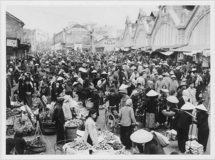 Cảnh họp chợ phía trước chợ Đồng Xuân, Hà Nội dịp Tết Nguyên đán Ất Mùi, 1955. Ảnh: Viện Viễn Đông Bác Cổ (EFEO).