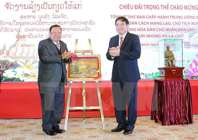 Trong khuôn khổ chuyến thăm hữu nghị chính thức Việt Nam, chiều 20/12, Tổng Bí thư, Chủ tịch nước Lào Bounnhang Vorachith và Đoàn đại biểu cấp cao của Đảng, Nhà nước Lào đã đến thăm tỉnh Nghệ An. Trong ảnh: Tổng Bí thư, Chủ tịch nước Lào Bounnhang Vorachith tặng tranh cho cán bộ, nhân dân tỉnh Nghệ An. (Ảnh: TTXVN)