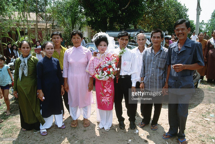 Cô dâu và chú rể chụp ảnh kỷ niệm trong lễ cưới ở Sài Gòn đầu thập niên 1990. Ảnh: Owen Franken / Getty.