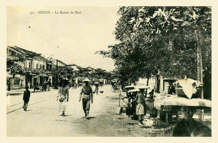 Đời thường trên phố Huế xưa. Những người phụ nữ đang lấy nước ở vòi nước công cộng trên vỉa hè (bên phải).