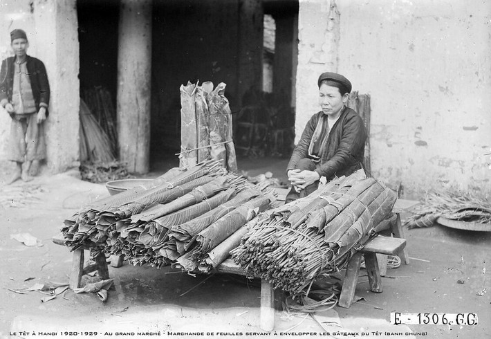 Người bán lá dong gói bánh chưng tại chợ Đồng Xuân, thập niên 1920.