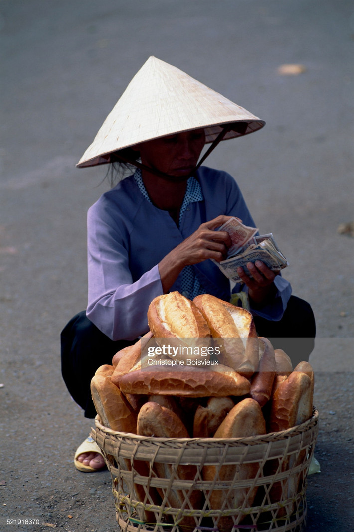 Người bán bánh mì kiểm đếm tiền bán hàng thu được.