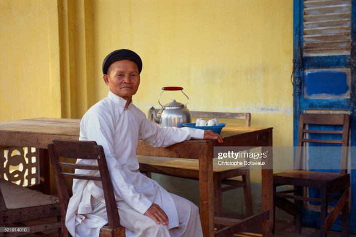 Một vị chức sắc Cao Đài ngồi bên bàn trà.