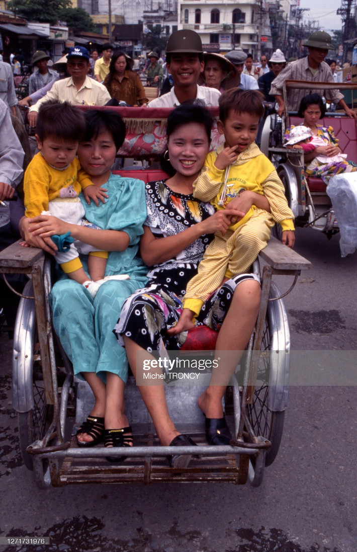 Phụ nữ và trẻ em trên xe xích lô ở Hà Nội, Việt Nam thập niên 1990. Ảnh: Michel Troncy/ Getty Images.