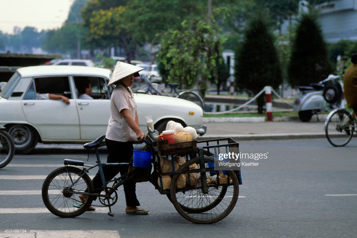 Người bán nước dừa dạo đi qua vòng xoay Cây Liễu, ngã tư Lê Lợi - Nguyễn Huệ.