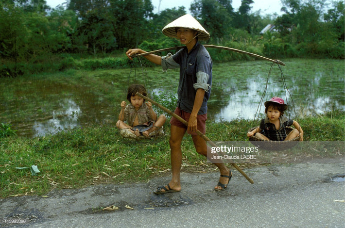 Ông bố gánh hai đứa con trên Quốc lộ 1.
