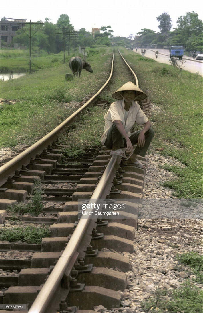 Một nam giới ngồi trên đường ray tàu hỏa ở Hà Tây, nay thuộc Hà Nội.